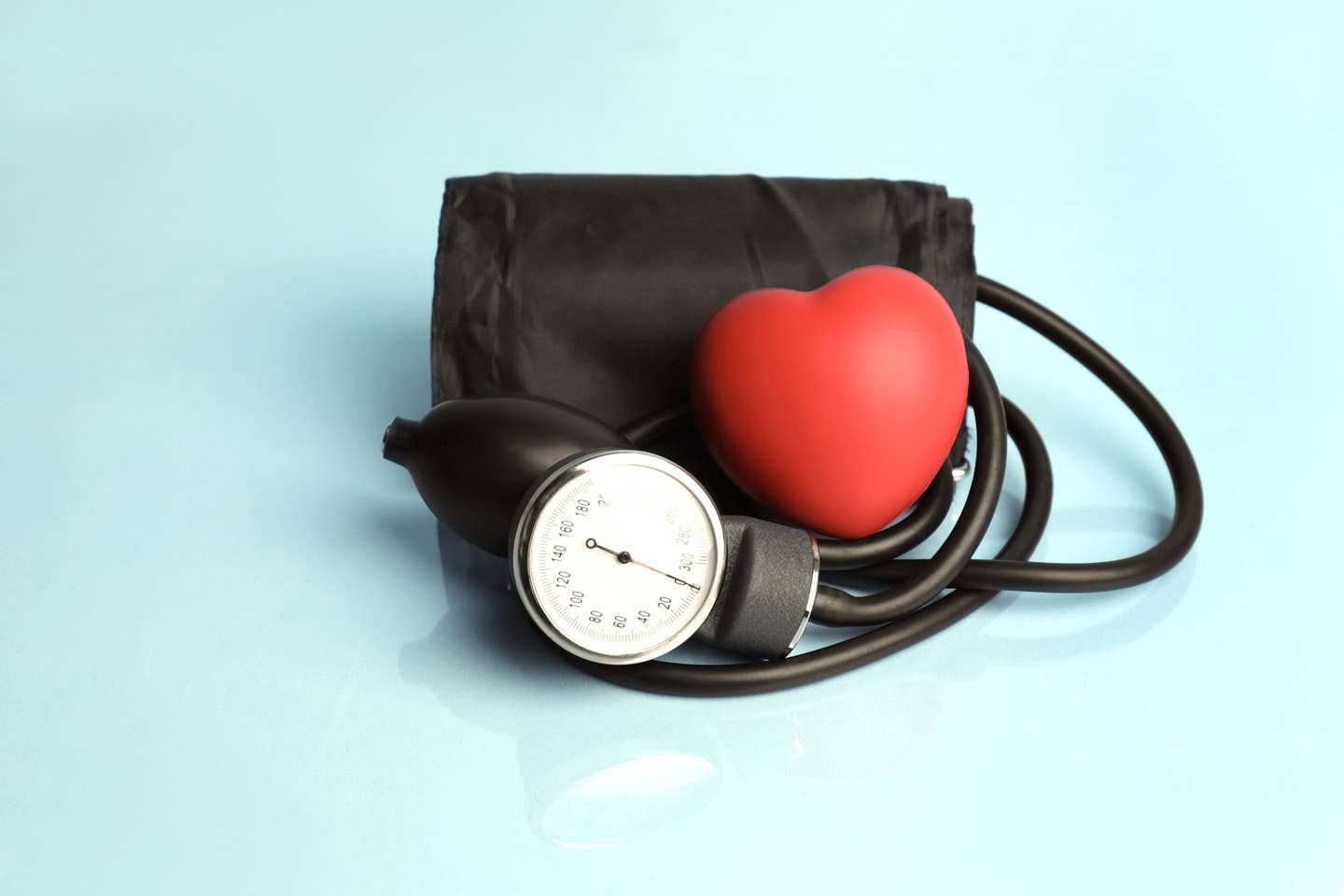 Blood pressure cuff with a palm-sized red heart next to it