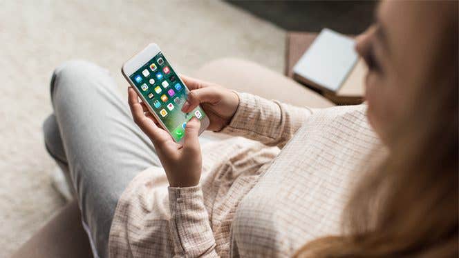 Woman looks down at the apps on her phone's home screen