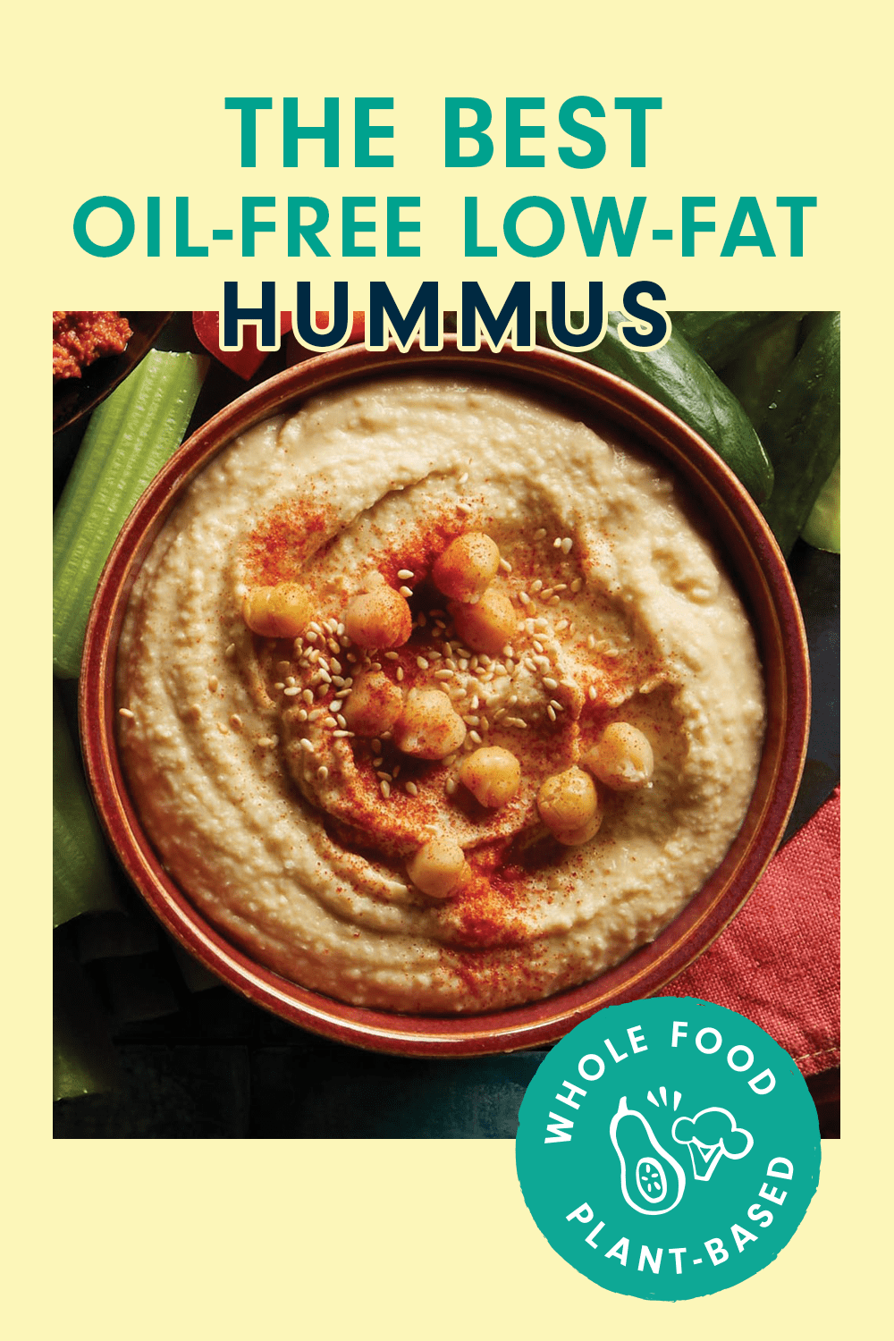 A bowl of hummus garnished with sesame seeds, chickpeas, and a red spice. text reads, "The best Oil-Free Low-Fat Hummus"