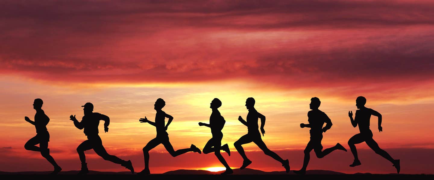 Silhouettes of men running against a sunset