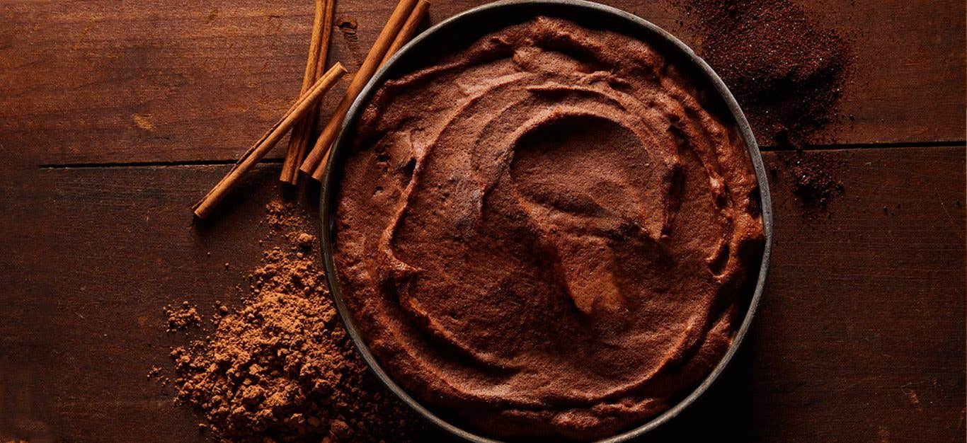 Mexican Chocolate Nice Cream against a dark wood background with cinnamon sticks and ground cinnamon