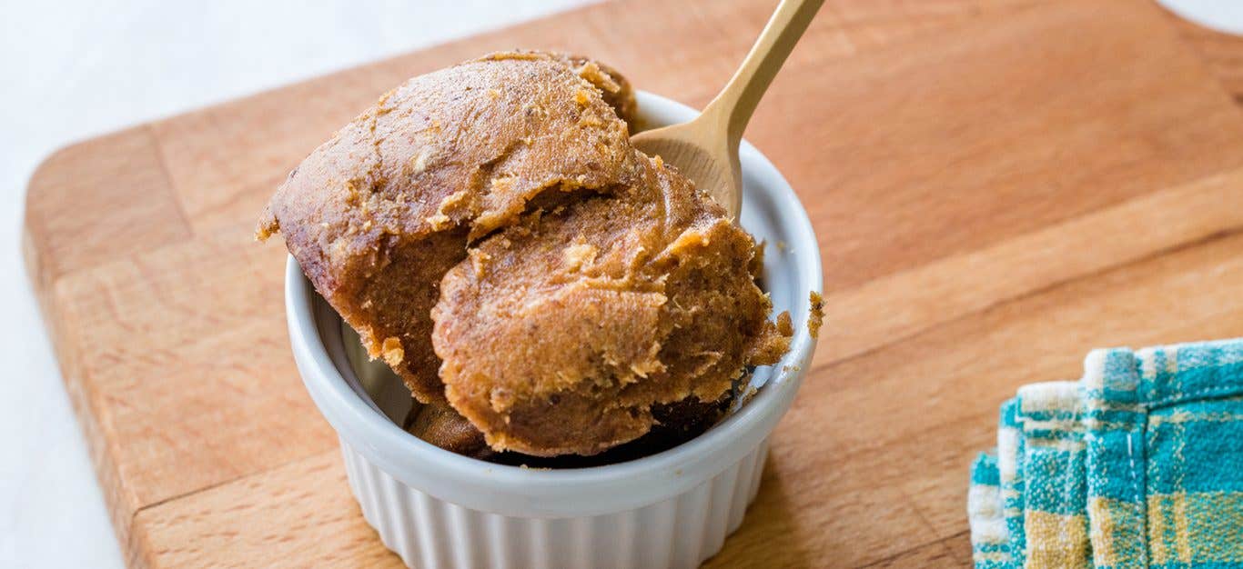 miso paste in a ramekin on a wooden cutting board with a wooden spoon inserted into the paste