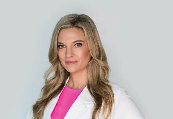 A headshot of Surgeon Kristi Funk wearing a white lab coat and a pink t-shirt.