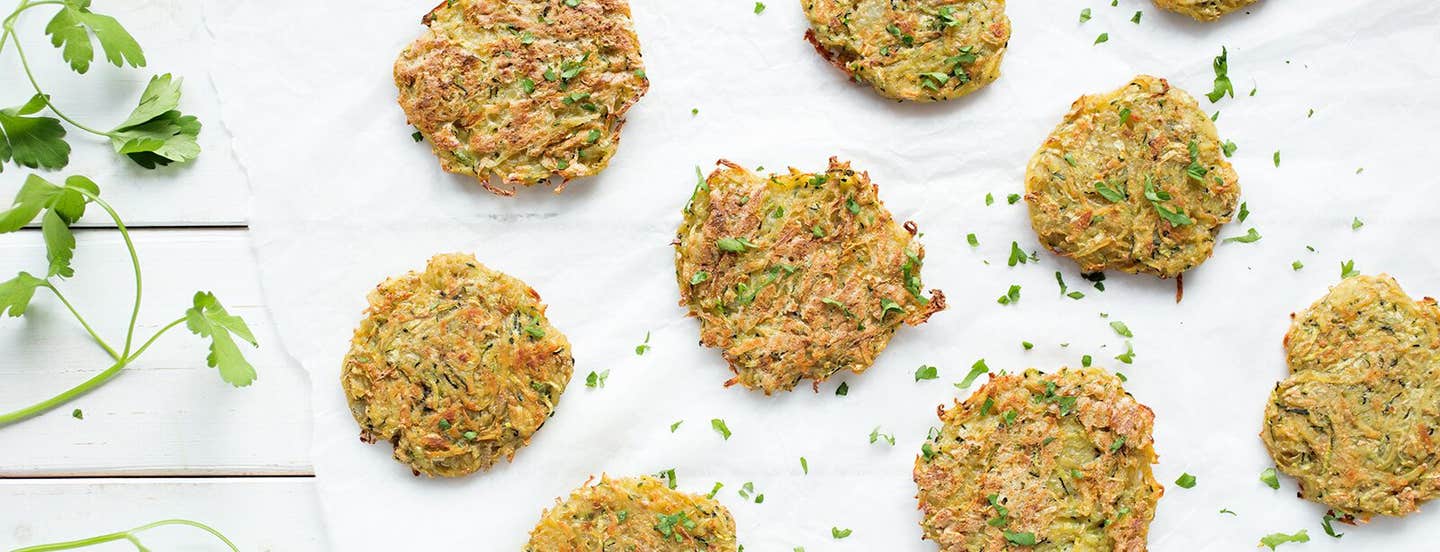 Potato Pancakes on white baking paper on a white table with finely chopped flat-leaf parsley sprinkled throughout