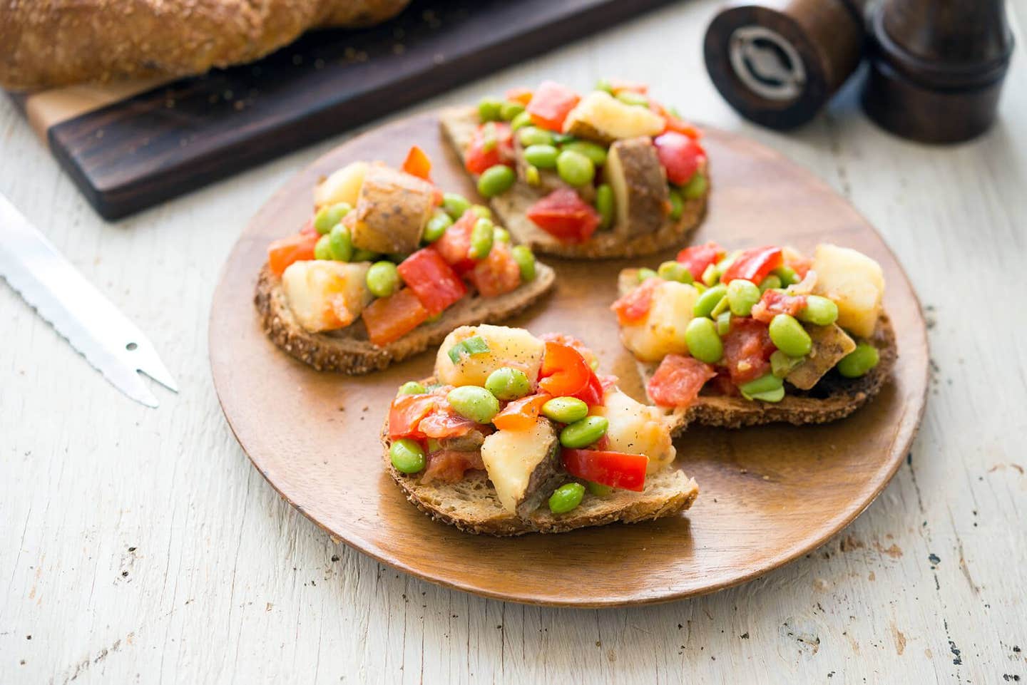 Four slices of Potato-Edamame Hash on Toast on a wooden plate