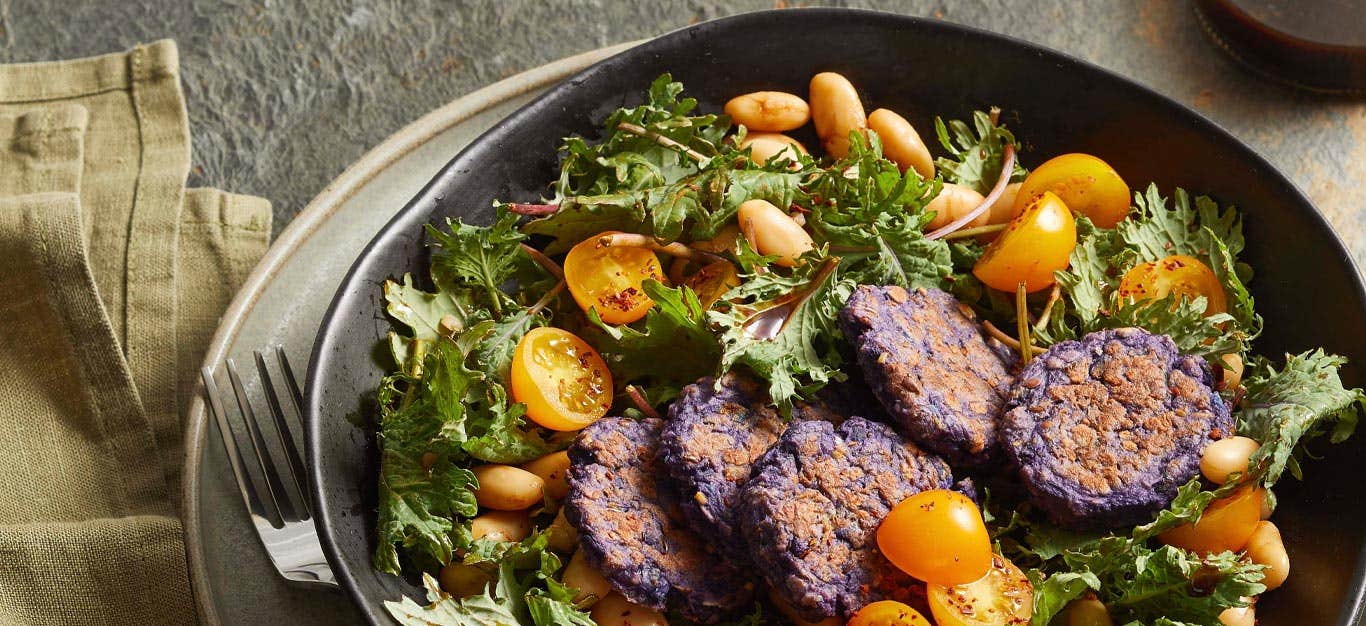 Purple Potato Croquettes with Kale Salad in a gray ceramic bowl