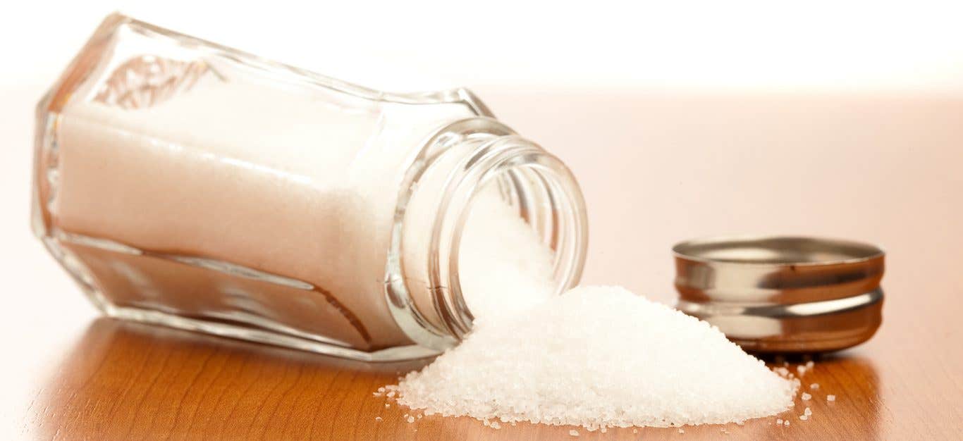 salt shaker spilled out onto a wooden table