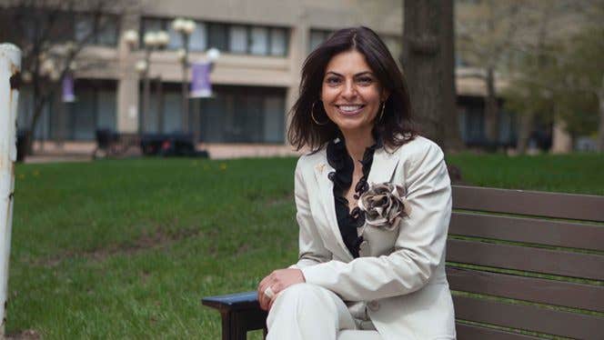 Dr. Saray Stancic sitting on a park bench in the city