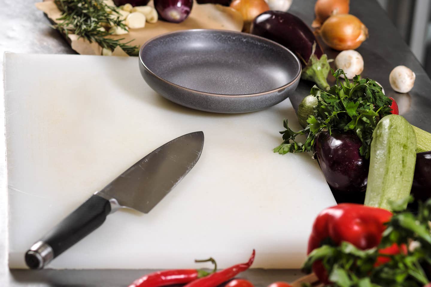 Vegetables and a chef's knife are lying on a white cutting board at the bottom of the restaurant.