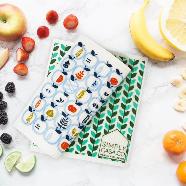 SWEDISH DISHCLOTHS SURROUNDED BY FRESH FRUIT ON A WHITE COUNTER